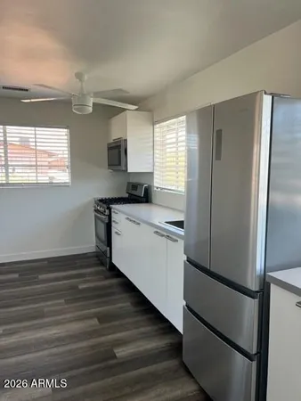 a kitchen with stainless steel appliances a refrigerator sink and microwave