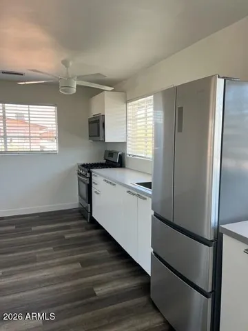a kitchen with stainless steel appliances a refrigerator sink and microwave
