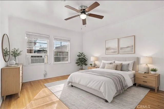 a bedroom with a large bed chandelier and a window