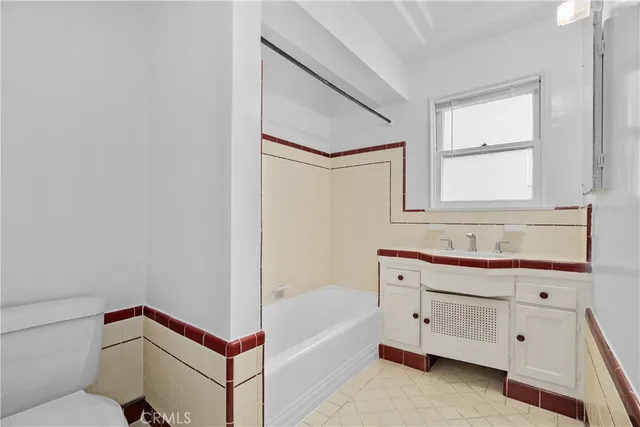 a bathroom with a bathtub sink and mirror
