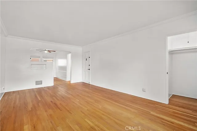 a view of empty room with wooden floor