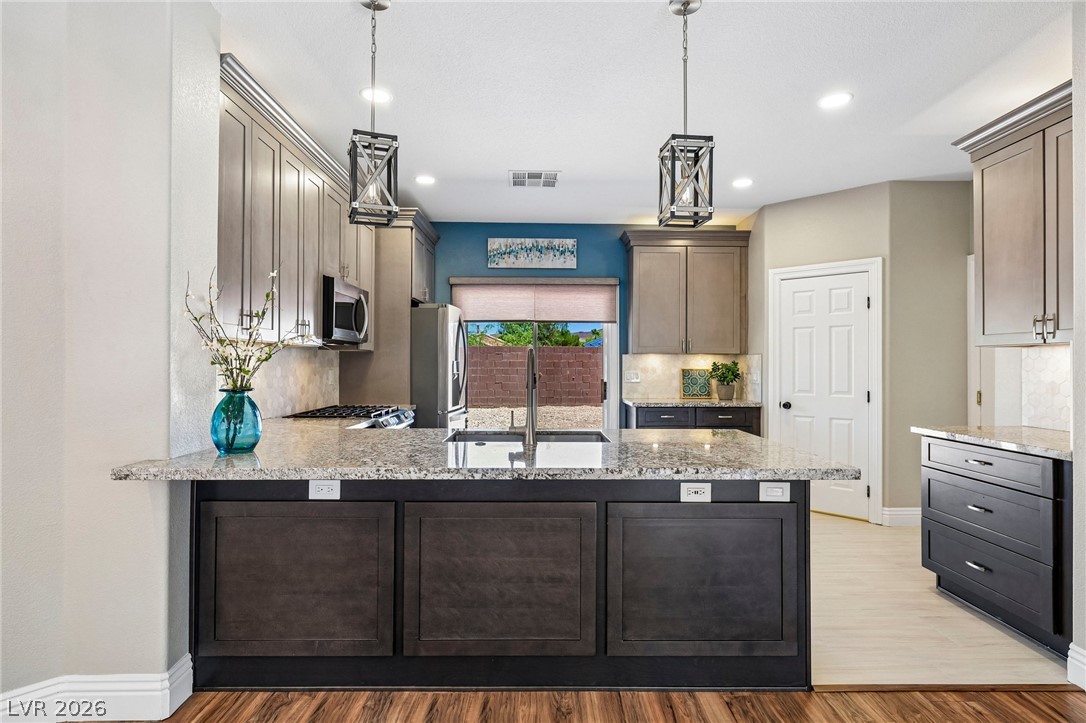 1176 Butternut Ranch Court Henderson, NV 89052 - Photo 12 of 60 Culinary adventures await in this kitchen featuring abundant granite counters and modern appliances.