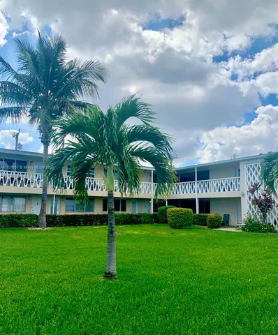 a view of a big house with a big yard plants and large trees