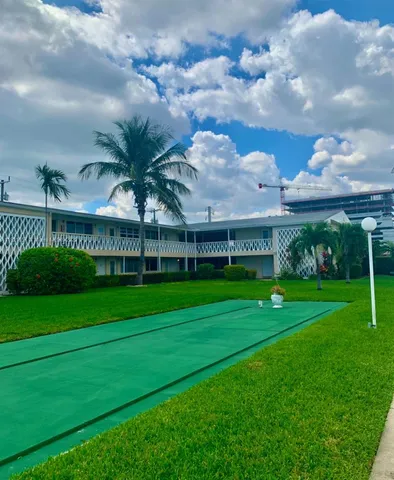 a view of house with a big yard and potted plants