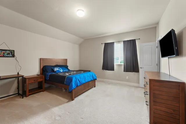 a spacious bedroom with a bed and a flat screen television