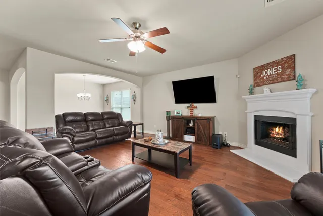 a living room with furniture a fireplace and a flat screen tv