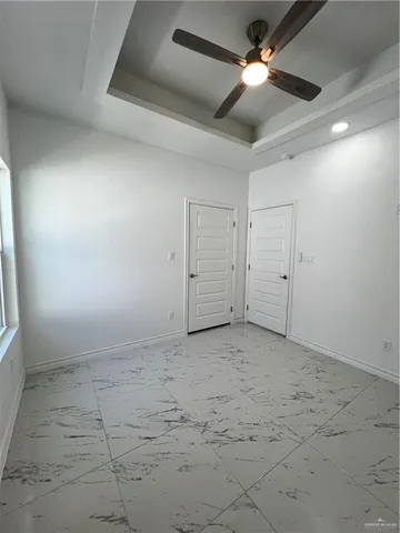 an empty room with a ceiling fan and window