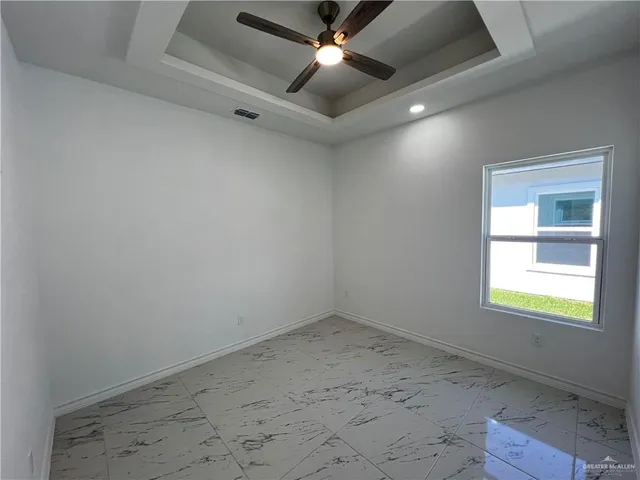 an empty room with a window and a fan
