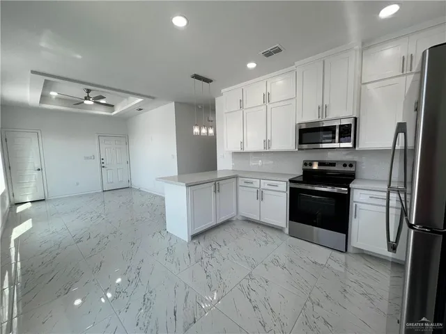 a kitchen with a refrigerator and a stove top oven