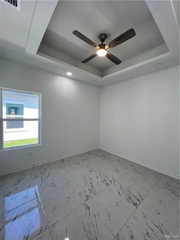 an empty room with a ceiling fan and window