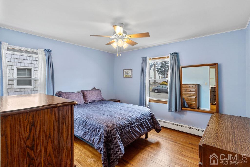 155 East Hill Road Colonia, NJ 07067 - Photo 15 of 37 a bedroom with a bed and a dresser with wooden floor