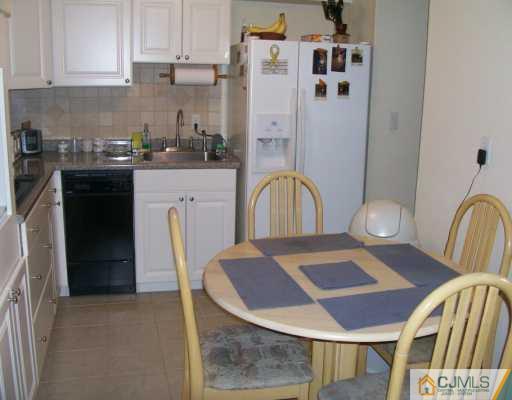 47 Haven Road Old Bridge, NJ 08857 - Photo 2 of 8 a kitchen with a table chairs and a refrigerator