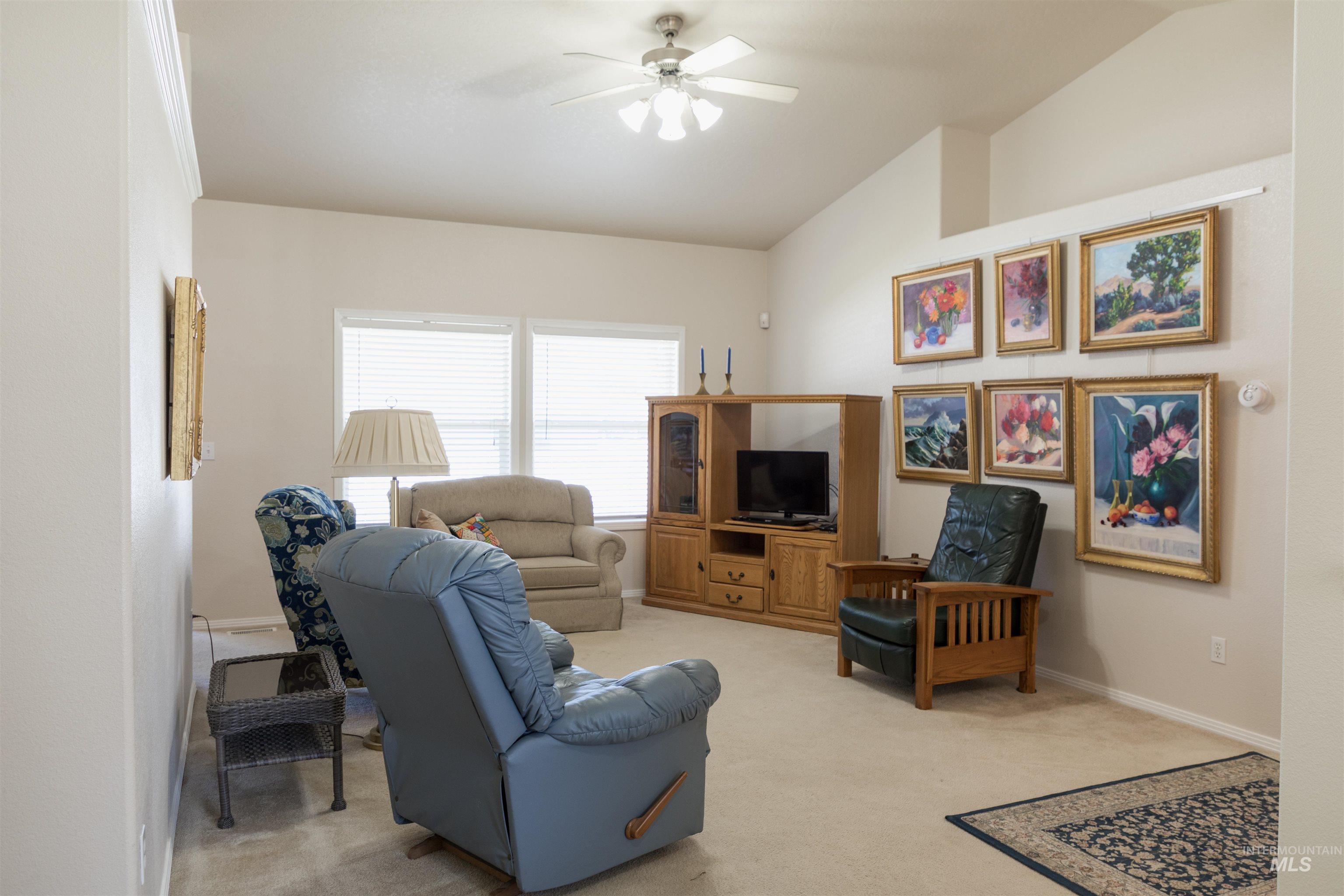 1003 Partridge Street Fruitland, ID 83619 - Photo 14 of 48 Living room with vaulted ceiling, light carpet, and a ceiling fan