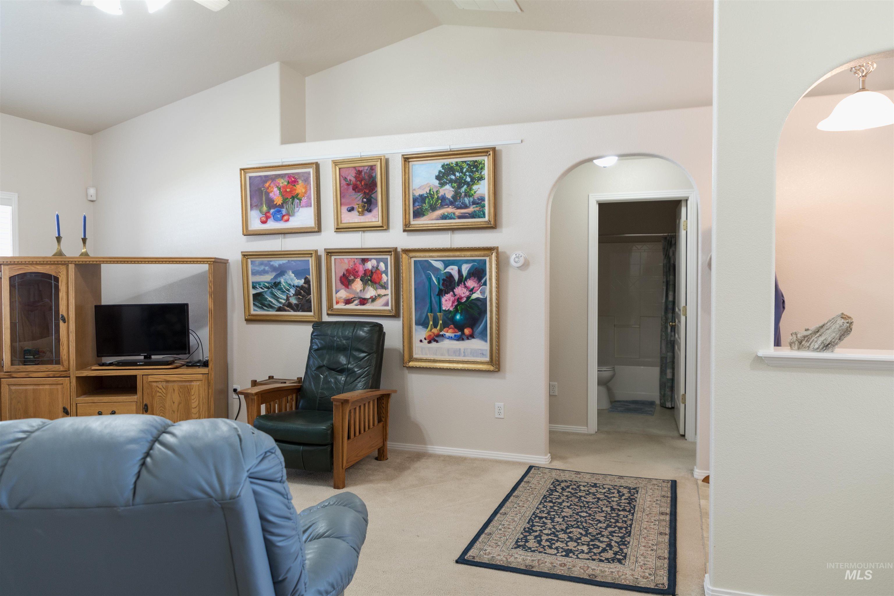 1003 Partridge Street Fruitland, ID 83619 - Photo 15 of 48 Living room featuring vaulted ceiling, carpet floors, and arched walkways