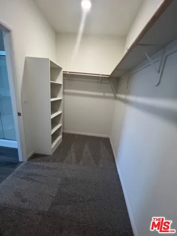 a view of walk in closet with empty racks