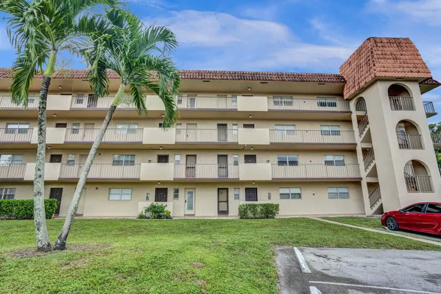 a view of a big building with a big yard and large trees