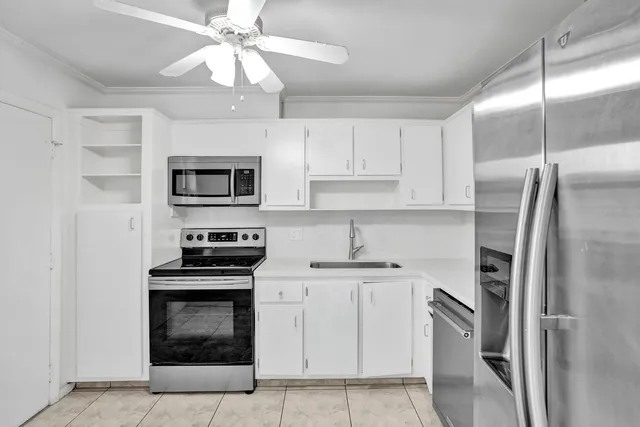 a kitchen with cabinets stainless steel appliances and a counter space