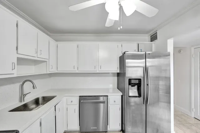 a kitchen with stainless steel appliances granite countertop a refrigerator and a sink