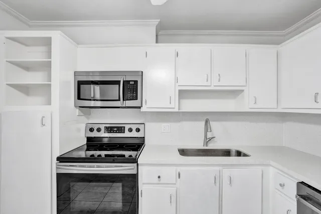 a kitchen with white cabinets and stainless steel appliances