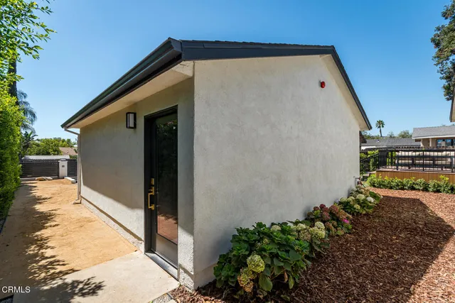 a front view of a house with a tree