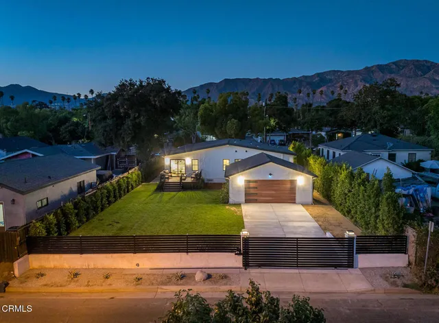 an aerial view of residential houses with outdoor space and trees