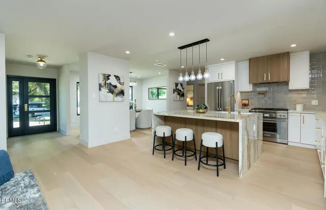 a large kitchen with stainless steel appliances granite countertop a stove and a refrigerator