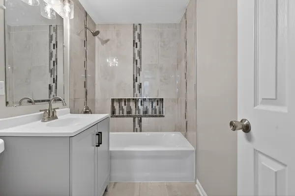 a bathroom with a tub sink and mirror