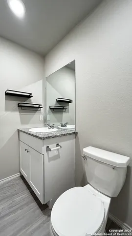 a bathroom with a granite countertop toilet and a sink