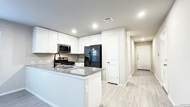 a kitchen with refrigerator a sink and cabinets