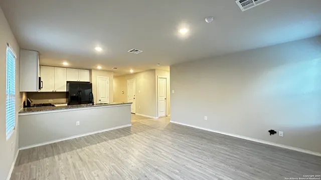 a kitchen with stainless steel appliances wooden floor and large window