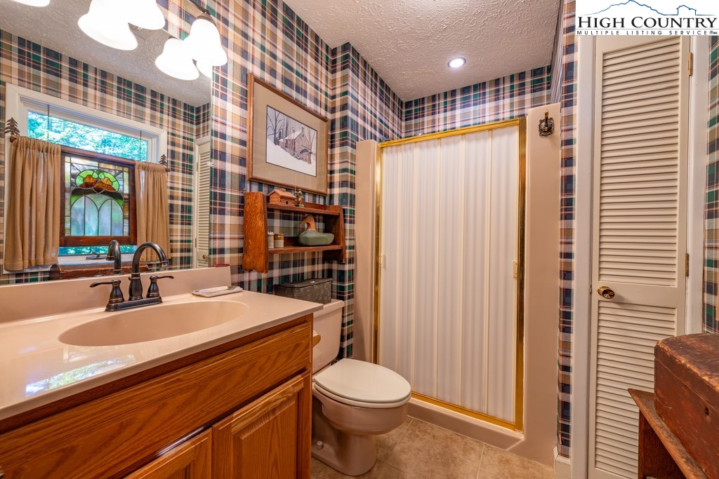307 Lakeview Road Newland, NC 28657 - Photo 34 of 49 a bathroom with a sink a toilet a mirror and shower