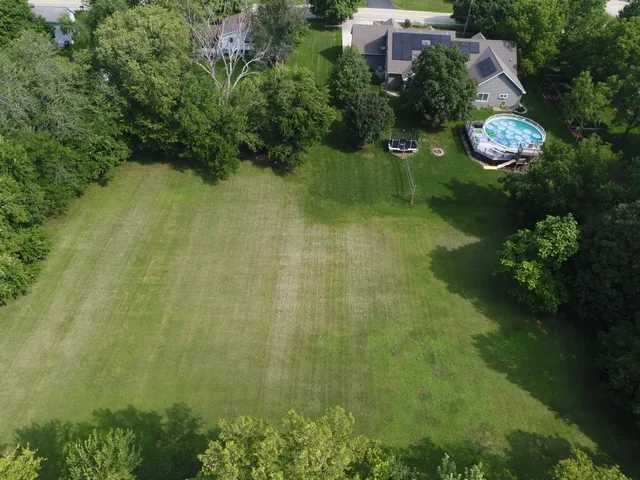 an aerial view of residential house with outdoor space and trees all around