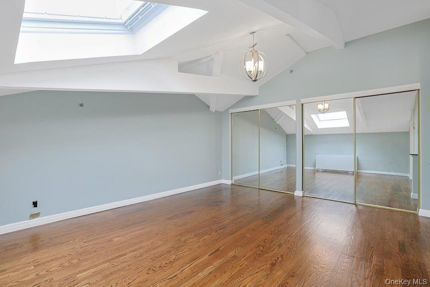 1701 Crompond Road, Unit 6304 Peekskill, NY 10566 - Photo 11 of 23 an empty room with wooden floor chandelier and windows