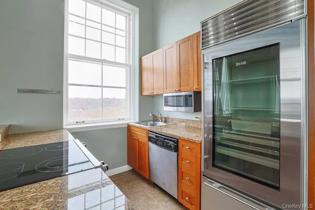 a kitchen with stainless steel appliances granite countertop a sink and a stove