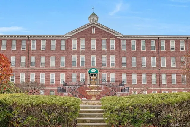 a front view of a building with a garden