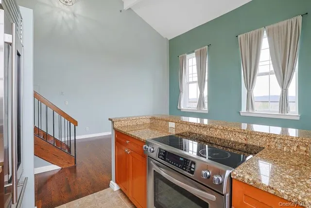 a kitchen with granite countertop a sink a stove and cabinets