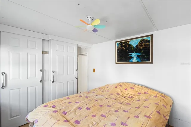 a bedroom with a bed and a dresser next to a window