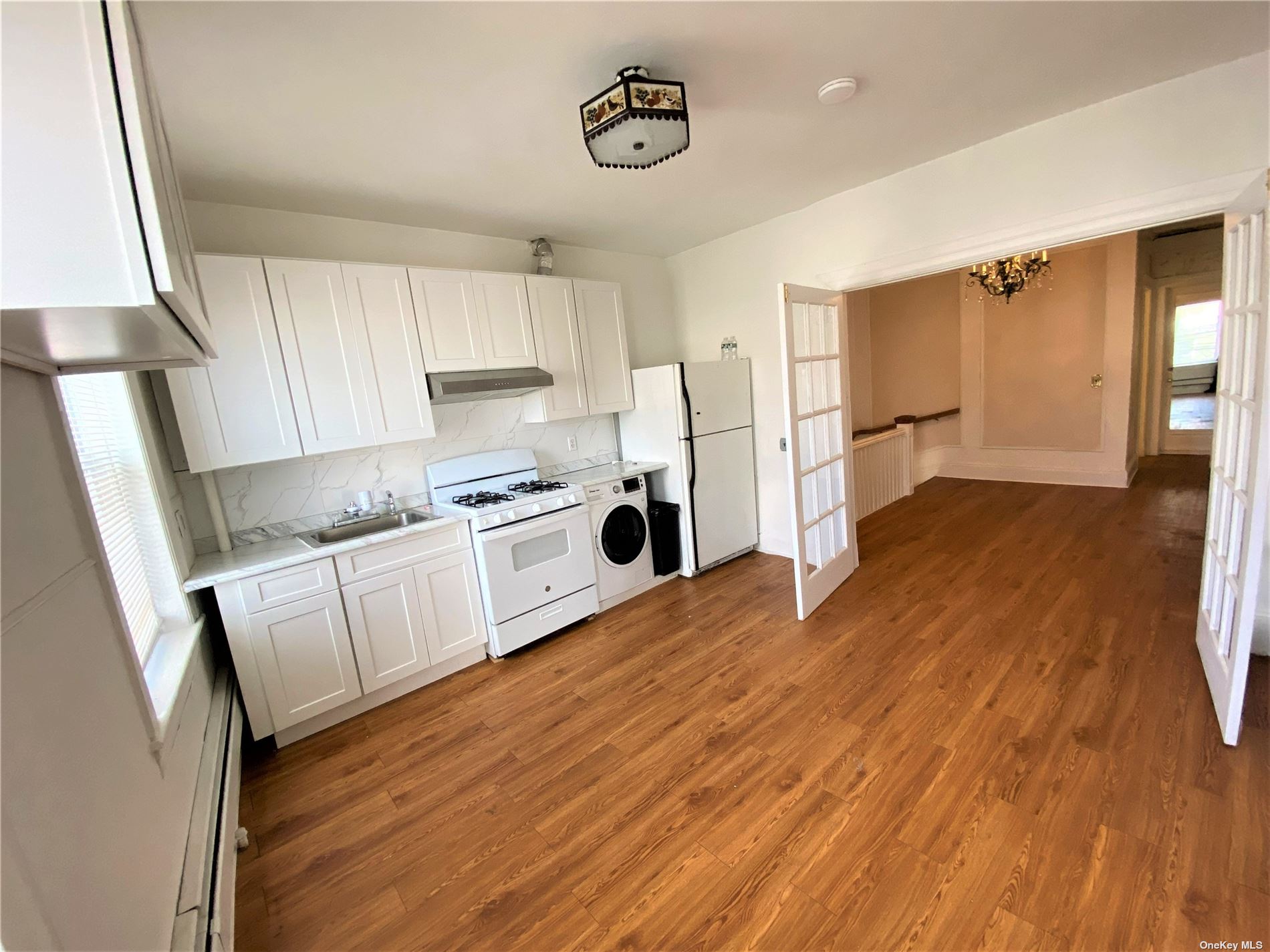 a kitchen with wooden floors and white appliances