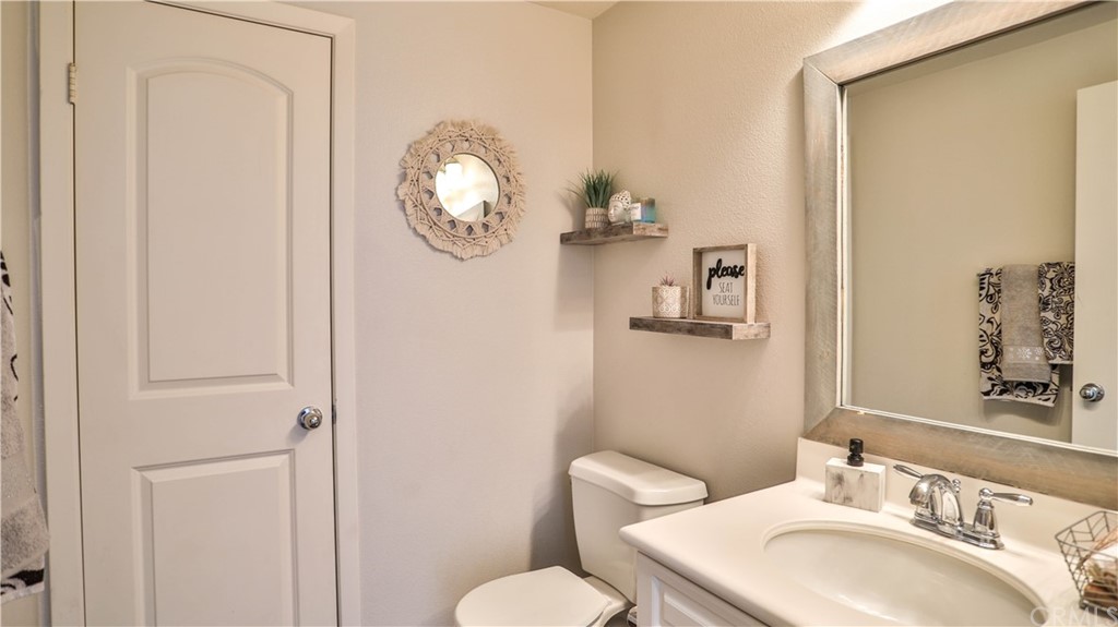 12179 Dewar Drive Riverside, CA 92505 - Photo 13 of 28 a bathroom with a toilet a sink and a mirror