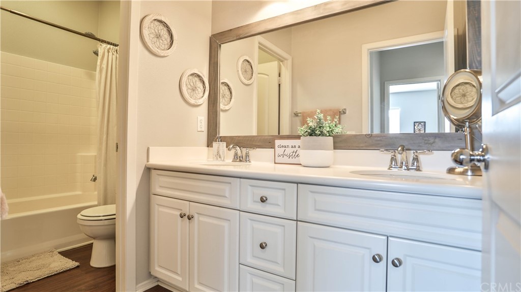 12179 Dewar Drive Riverside, CA 92505 - Photo 20 of 28 a bathroom with a granite countertop sink a toilet and a mirror