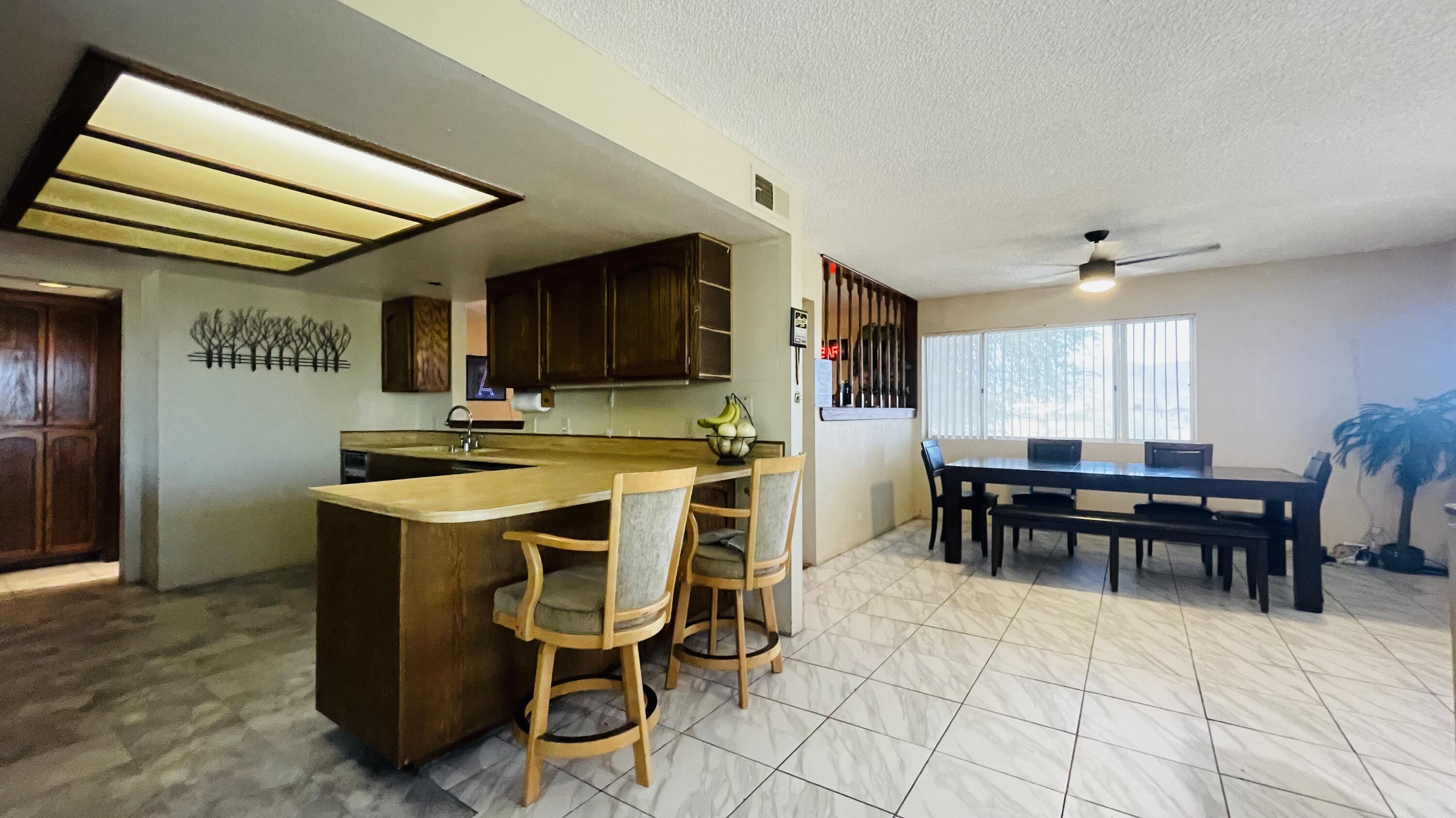 1498 Nile Drive Thermal, CA 92274 - Photo 23 of 108 a dining hall with stainless steel appliances granite countertop a stove a refrigerator a dining table and chairs with wooden floor