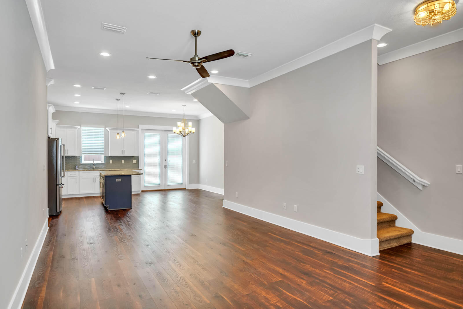 995 Airport Road, Unit 39 Destin, FL 32541 - Photo 11 of 37 a kitchen with stainless steel appliances a dining table chairs wooden floors and white cabinets