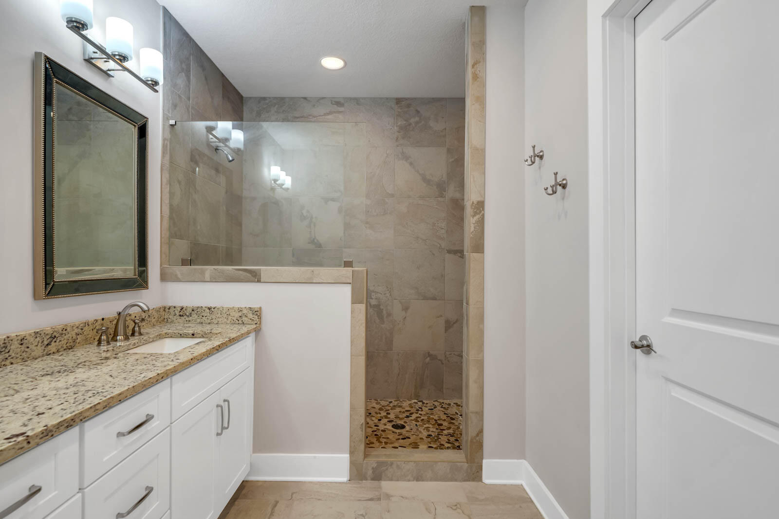 995 Airport Road, Unit 39 Destin, FL 32541 - Photo 18 of 37 a bathroom with a granite countertop sink a mirror and a shower