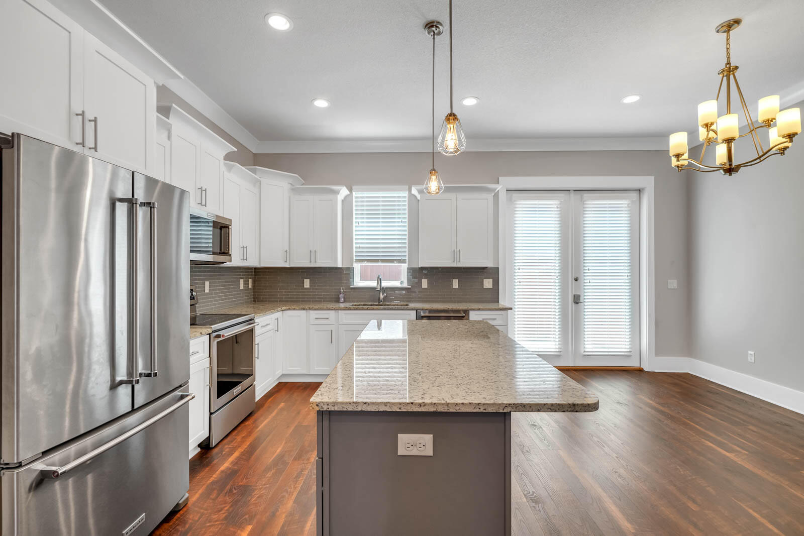 995 Airport Road, Unit 39 Destin, FL 32541 - Photo 4 of 37 a kitchen with a center island wooden floor stainless steel appliances and cabinets