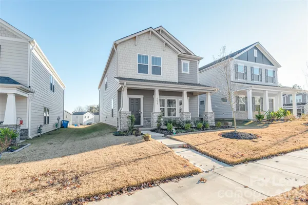 a view of a white house with a large windows next to a yard