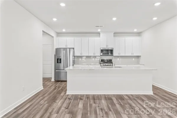a view of kitchen with stainless steel appliances granite countertop a stove a sink and a refrigerator