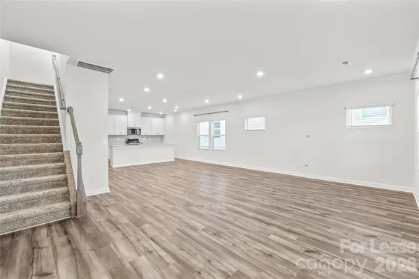 a view of empty room with wooden floor and windows