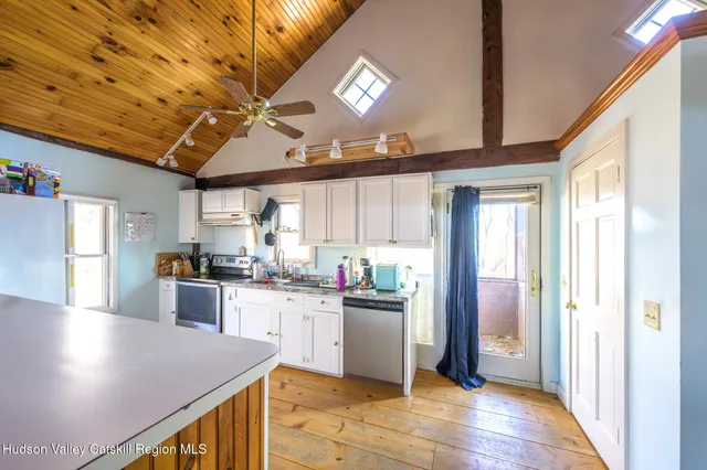 a kitchen with stainless steel appliances granite countertop a sink window and cabinets