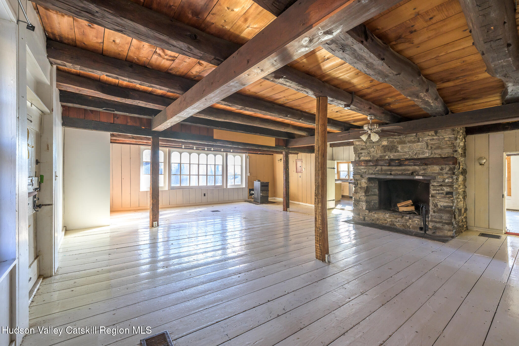 91 Scheller Park Road New Baltimore, NY 12192 - Photo 7 of 26 a view of an empty room with wooden floor fireplace and a window