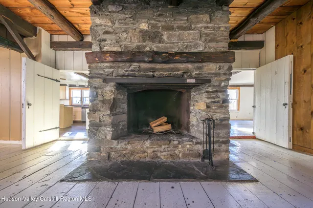 a view of a livingroom with wooden floor and a fireplace